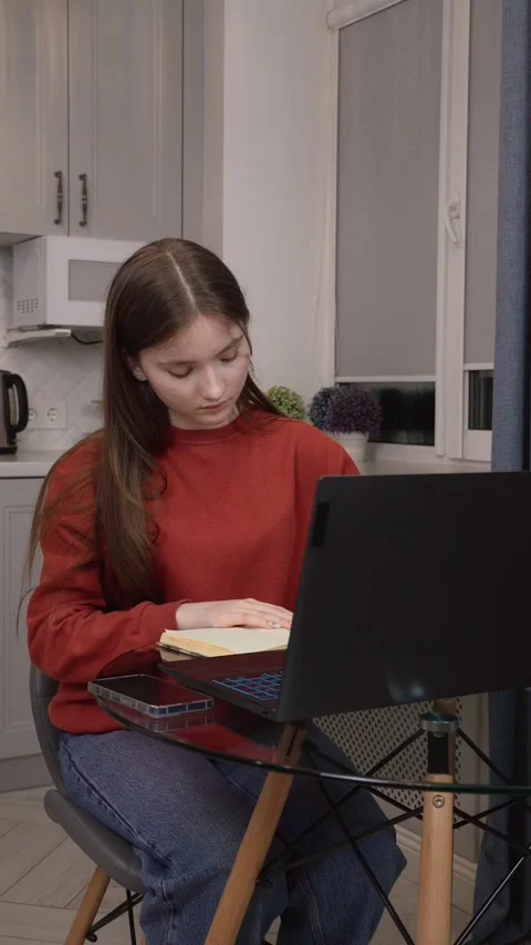 Student working from home using laptop and textbook 스톡 동영상 311813067