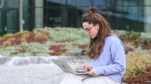 Student working on a laptop in a park Stock Footage 149823117