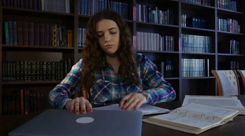 A student works at a computer in the library. 4K Stock Footage 63369805