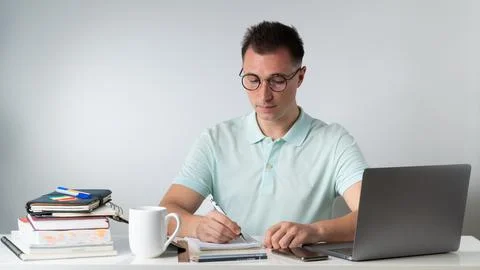 Student writes in notebooks - training, exam preparation, online education Stock Photos