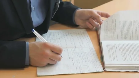 Student writes the text in a copybook on a lesson Stock Footage 70147893