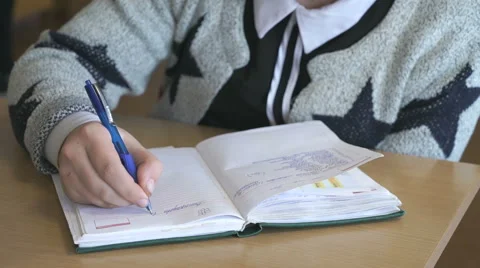 Student writes the text in the notebook indoors Stock Footage 68823260