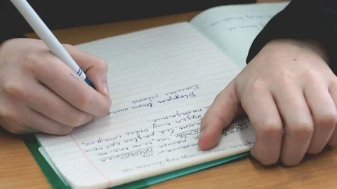 Student writes in a workbook with a ballpoint pen Stock Footage 77047344