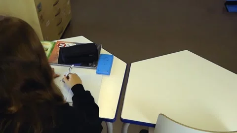 Student writing and doing homework at a school desk Video stock 344859655
