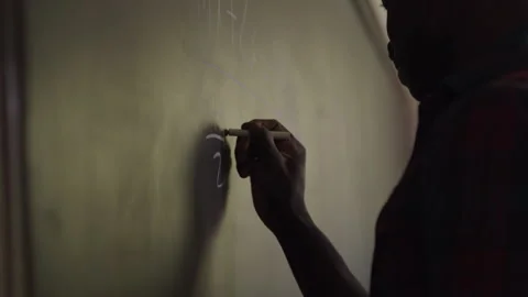 Student Writing On A Chalkboard In Classroom Video stock 210220688