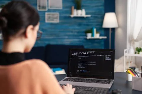 Student writing code on laptop in home office. Stock Photos