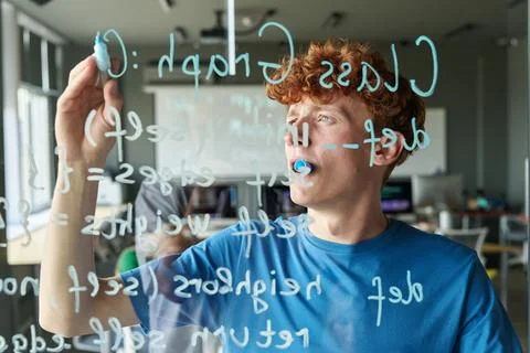 Student writing Computer Code on Glass Wall Stockfoto's