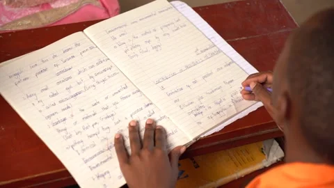 Student writing in her exercise book in his rural school in Africa Stock Footage 230078655