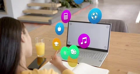 Student writing notebook, glancing at laptop and causing icons showing study Stock Footage 320895462