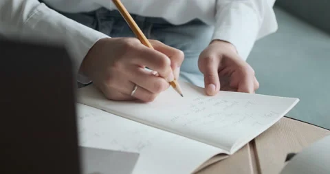 Student writing in notepad and doing homework preparing for exams. Stock Footage 156485119