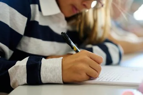 Student writing notes in a notebook during class Stock Photos