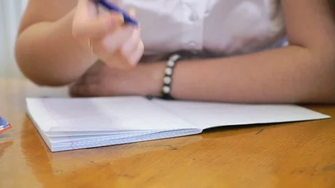 Student writing text in exercise book. Close-up Stock Footage 79545542