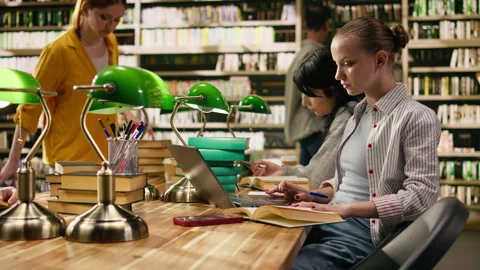 Student writing on textbook and loses focus after receiving phone notification Stock Footage 336358714