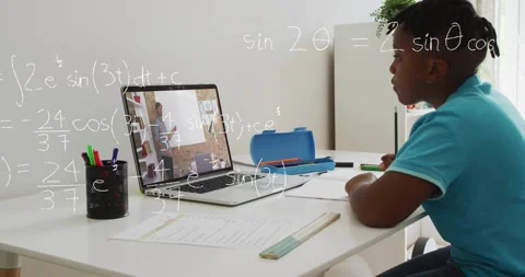 Student writing worksheet while laptop tutor gesturing, math overlays appearing Stock Footage 330563761