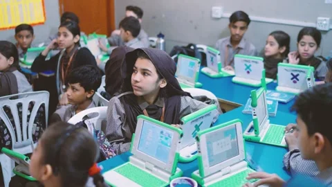 Students actively engaging with green laptops during an educational session in Stock Footage 330872409
