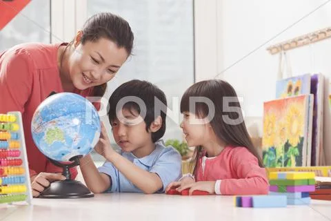 Students And Teacher Looking at Globe Stock Photos
