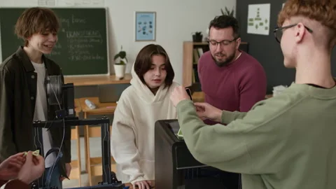 Students and Teacher Testing Phone Stand their 3D Printed Together in Class Stock Footage 335698922