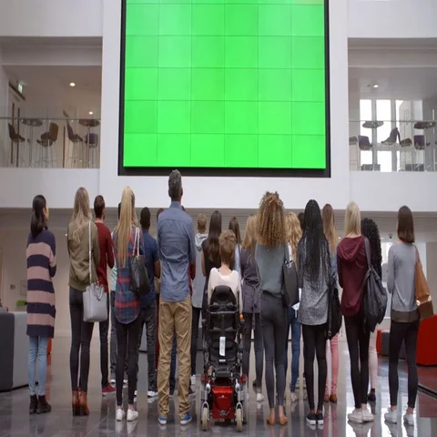 Students applaud a big screen in university foyer, back view Vídeos de archivo 69424548