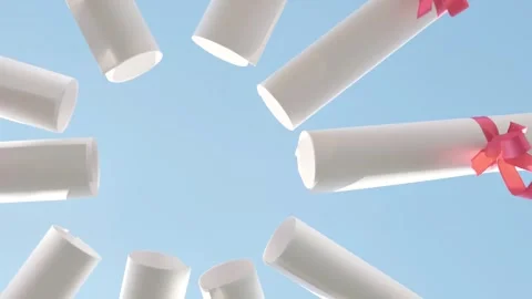 Students are celebrating their graduation by holding their diplomas up in the Stock Footage 308263022