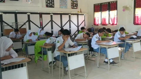 Students are filling out the width of the answers from the school exam questions Stock Footage 237043945