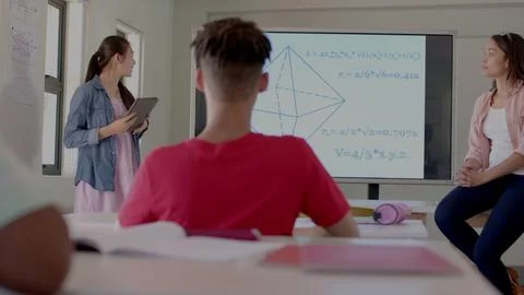Students are solving geometry problems on tablet with 3D pyramid screen in flat Foto stock