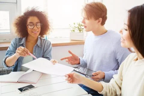 Students are solving problem. They are studying. Girls are holding a piece of Stock Photos