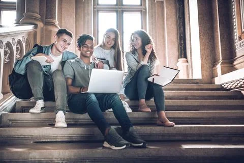 Students are spending time together.Multicultural young people using laptop w Stock Photos