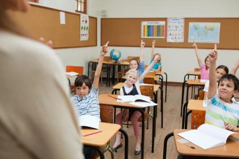 Students with arms raised in class Stock Photos