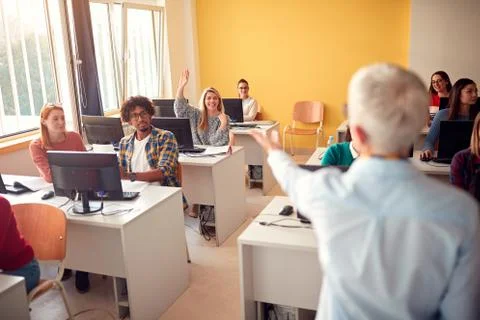 Students asking question while attending lecture in campus. Stock Photos