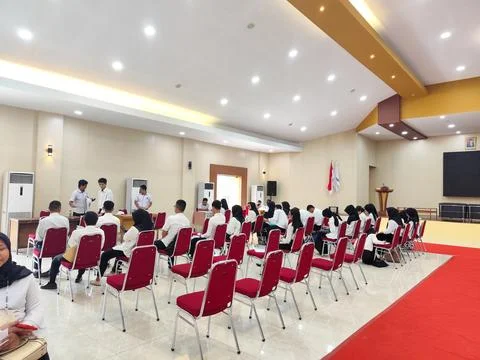 Students Attending Indoor Training Session in Conference Room with Red Chairs Stock Photos