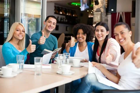 Students in cafe showing thumbs up Stock Photos