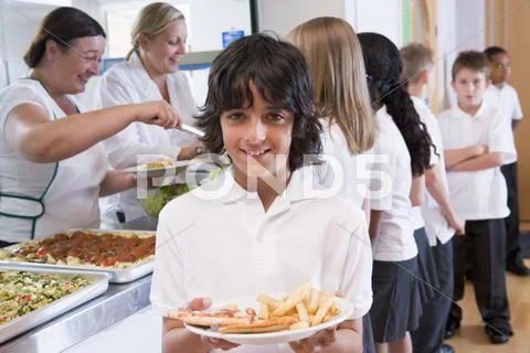 Students in cafeteria line with one holding his unhealthy meal and looking at Stock Photos