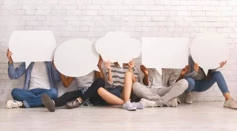 Students in casual clothes hiding behind speech bubbles Stock Photos