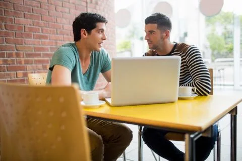 Students chatting in the cafe using laptop Stockfoto's