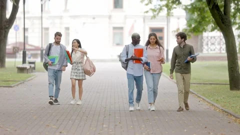 Students cheerfully walking after lectures through the park. slow motion. Stock Footage 221814264
