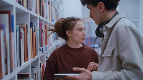 Students choosing a book together in a library Video stock 335127561