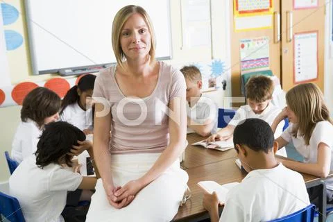 Students in class reading books with teacher in foreground Stock Photos