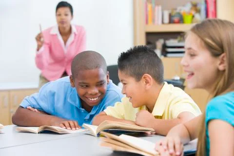 Students in class talking with teacher in background (selective focus) Stock Photos