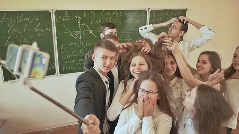 Students in the classroom amusingly do selfie on the background of the school Stock Footage 79548424