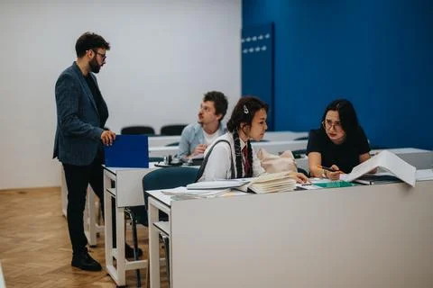 Students collaborating in class with professors guidance Stock Photos