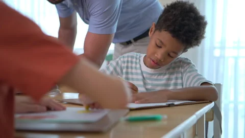 Students collaborating on drawing activity with one child thinking deeply Stock Footage 339376939