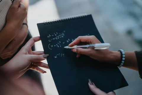 Students collaborating on mathematical problems outdoors in small group Foto stock