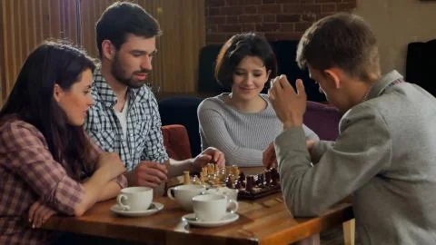 Students compony playing chess in cafe Stock Photos