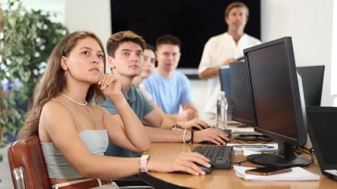 Students of computer courses sit in class near PC, watch to teacher and listen Stock Footage 265049767