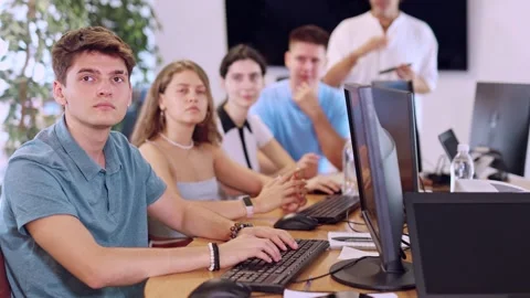 Students of computer courses sit in class near PC, watch to teacher and listen Stock Footage 313096188