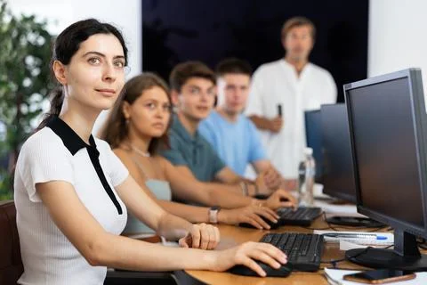 Students of computer courses sit in class near PC, watch to teacher and listen Stockfoto's