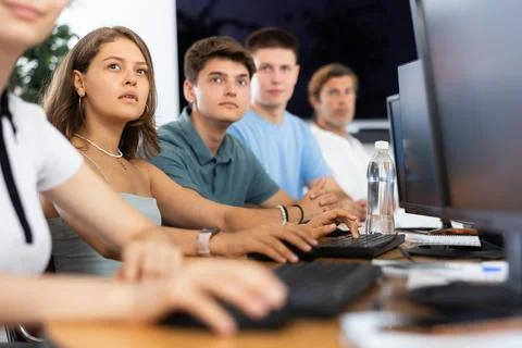 Students of computer courses sit in class near PC, watch to teacher and listen 写真素材