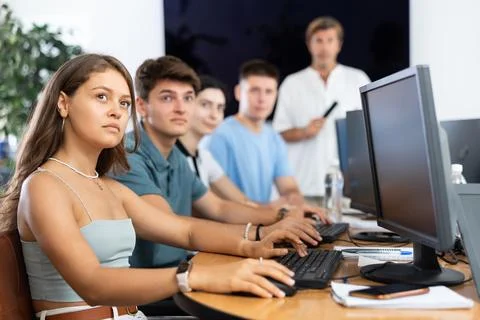Students of computer courses sit in class near PC, watch to teacher and listen 스톡 사진