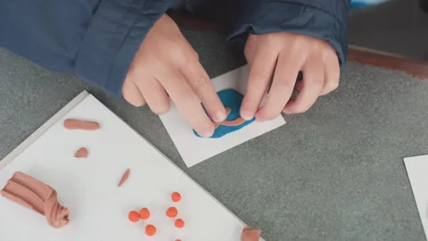 Students craft artwork. Learners manipulate colorful clay during class Stock Footage 333097873