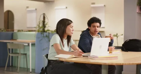 Students discussing assignment, taking notes and using white laptop at campus Stock Footage 342233416